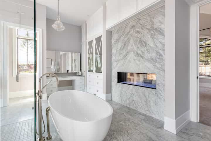 An elegant all white bathtub installation with custom fireplace for Anaheim, California home